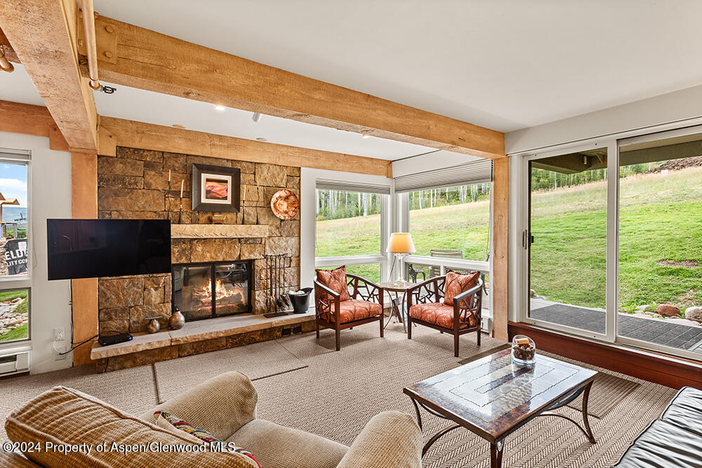 a living room with fireplace furniture and a large window