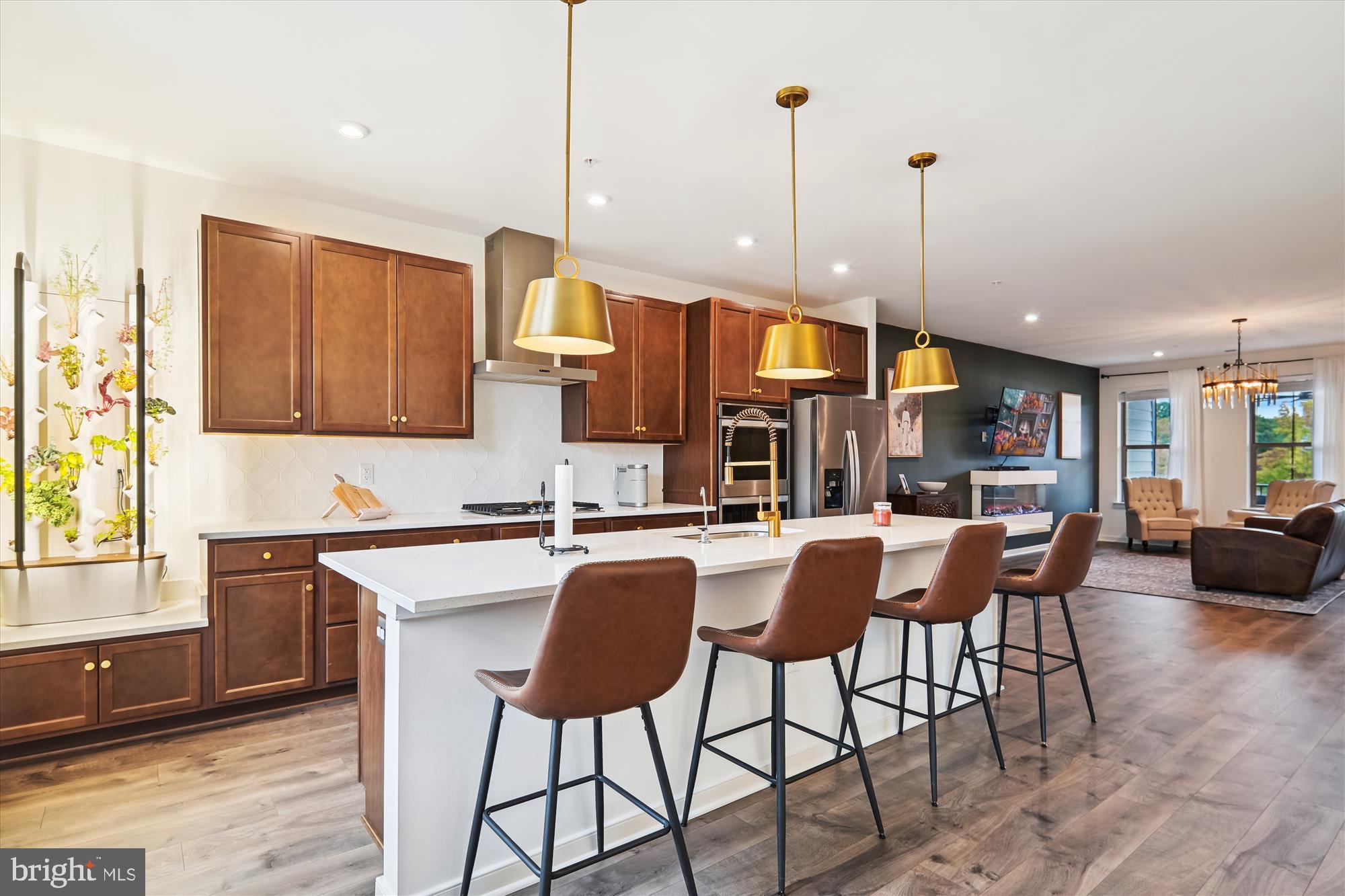 a kitchen with stainless steel appliances granite countertop table chairs and a wooden floor