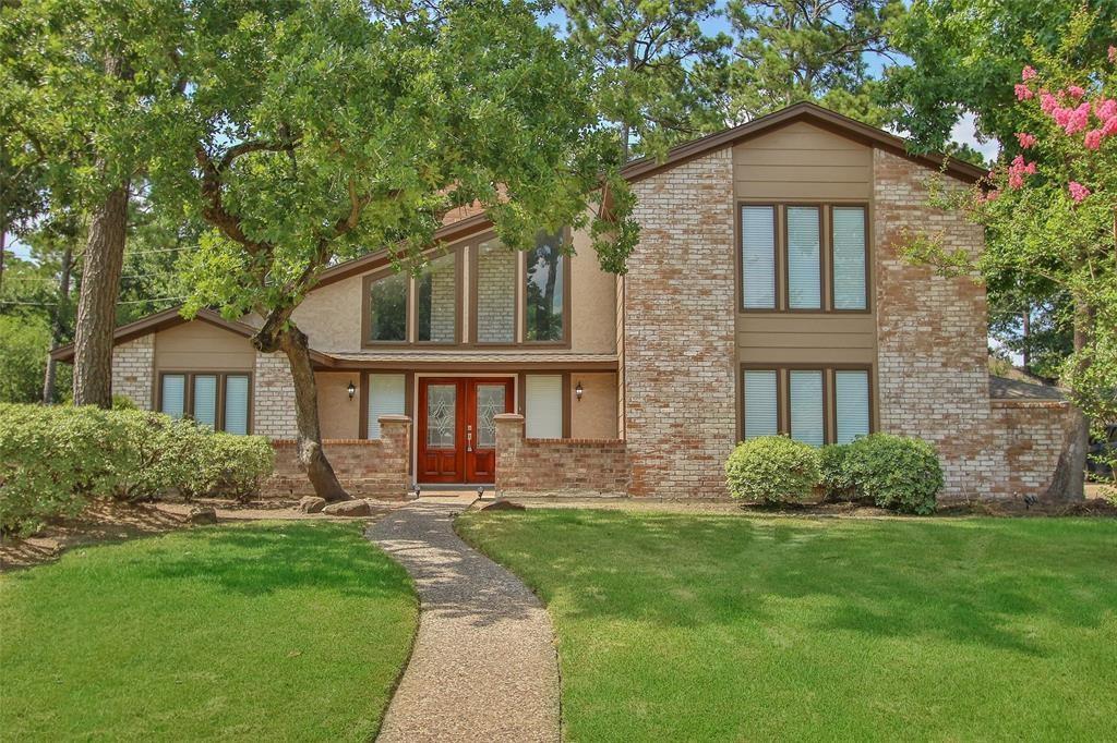 a front view of a house with a yard and trees