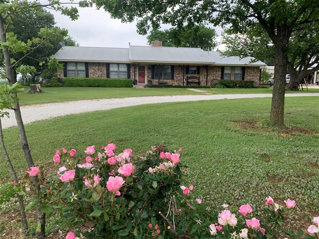 a front view of a house with a big yard and potted plants