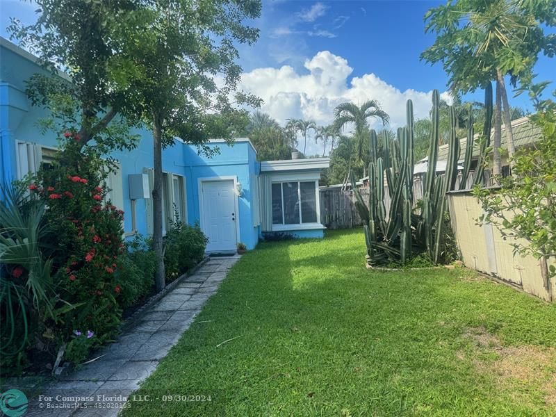 a view of a house with a yard and potted plants