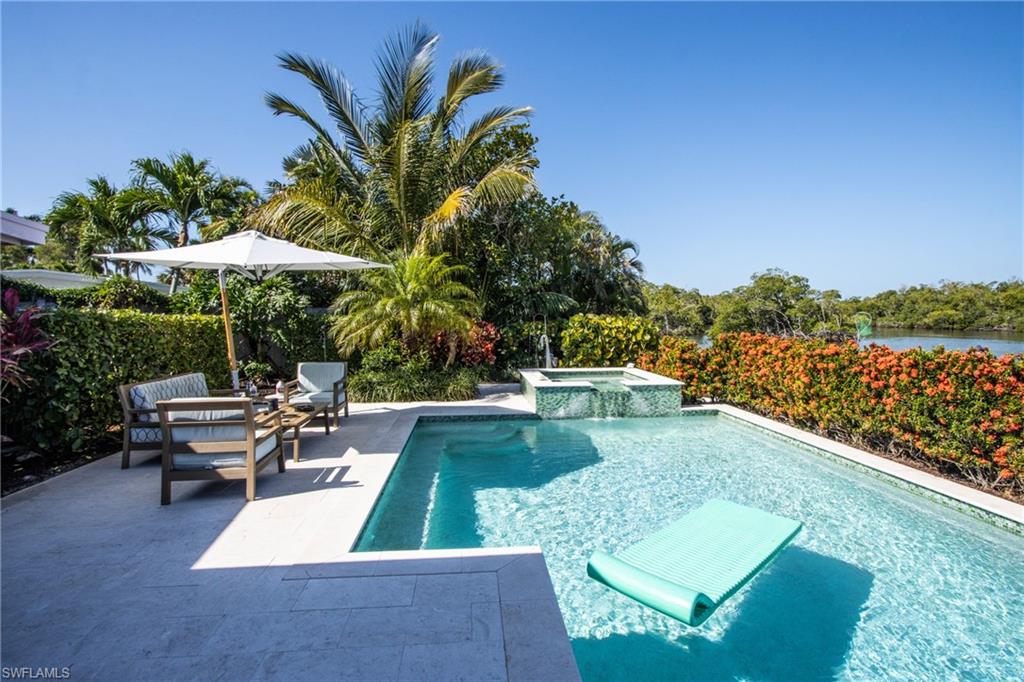 a view of a swimming pool with lounge chairs in patio