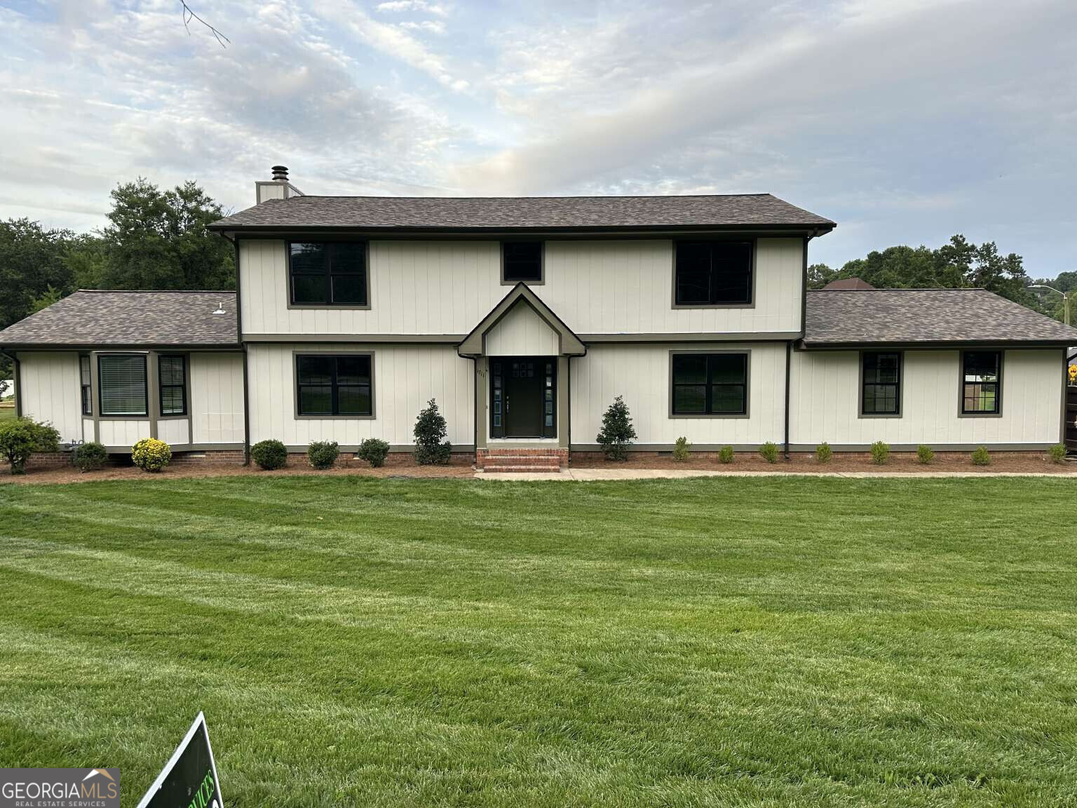 a front view of a house with a garden