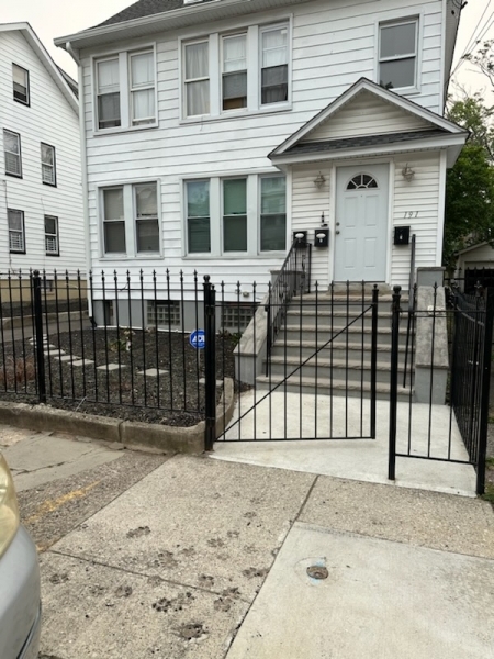 a view of a white house with a iron gate