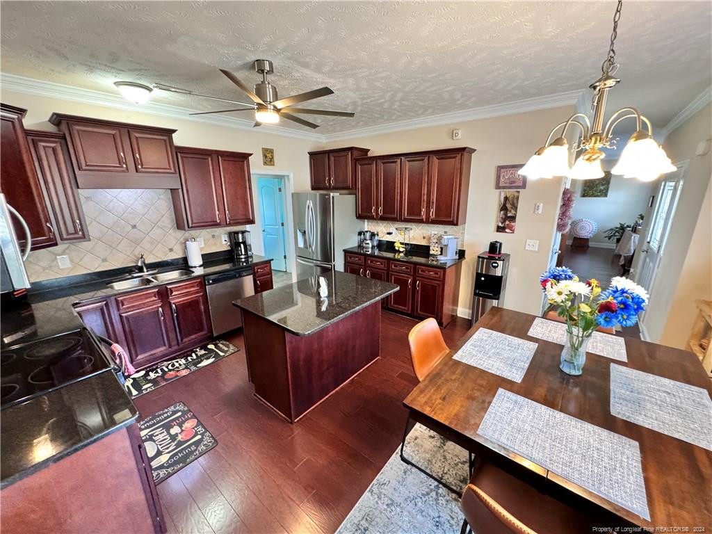 a living room with furniture kitchen view and a chandelier