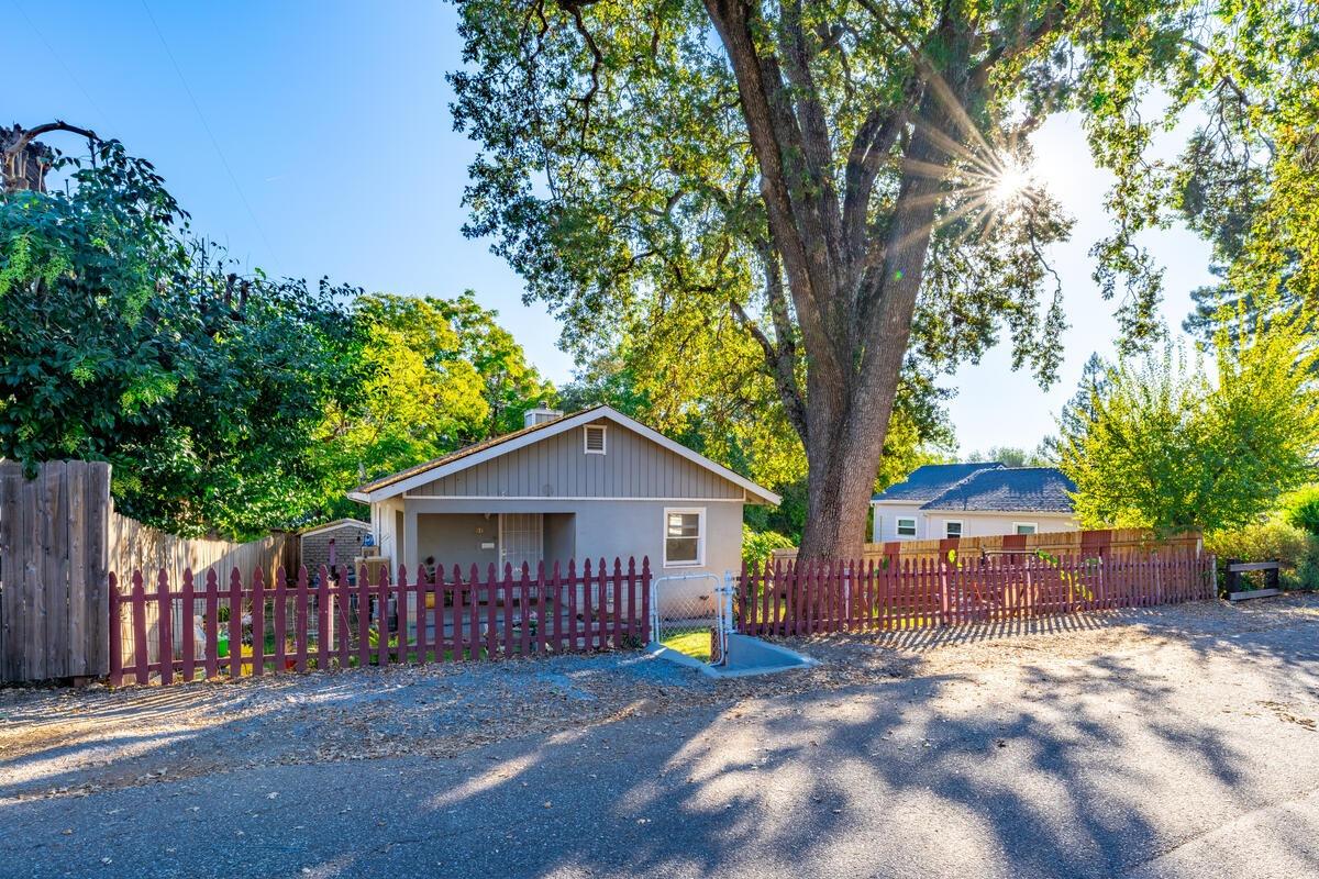 a view of a house with wooden fence next to a yard