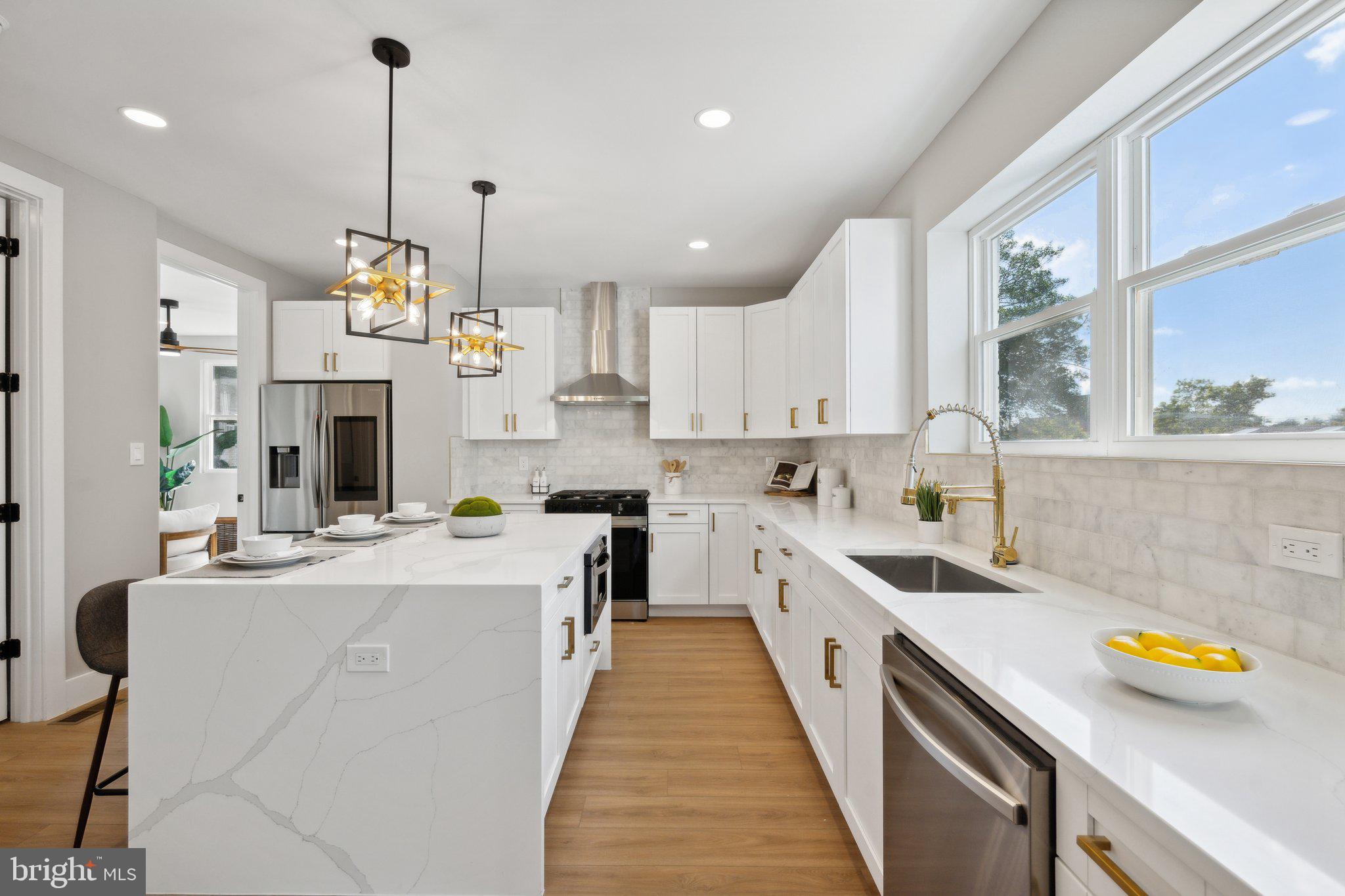 a kitchen with a sink a counter top space stainless steel appliances and a window