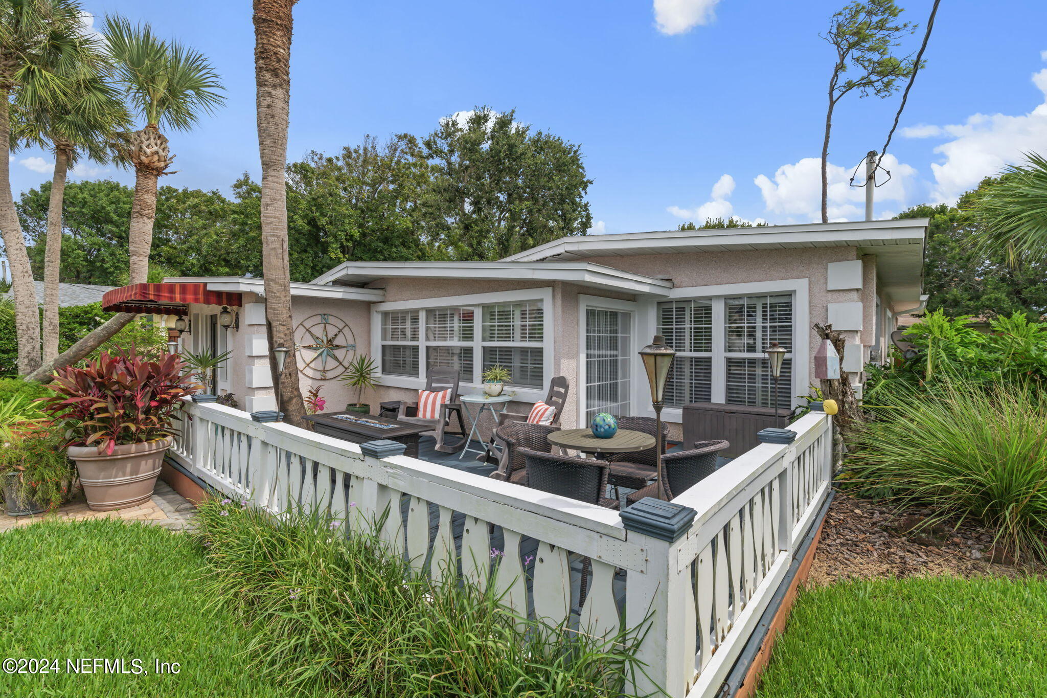 a view of a house with wooden deck and furniture