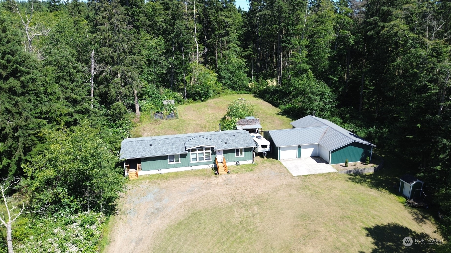 an aerial view of a house with swimming pool and large trees