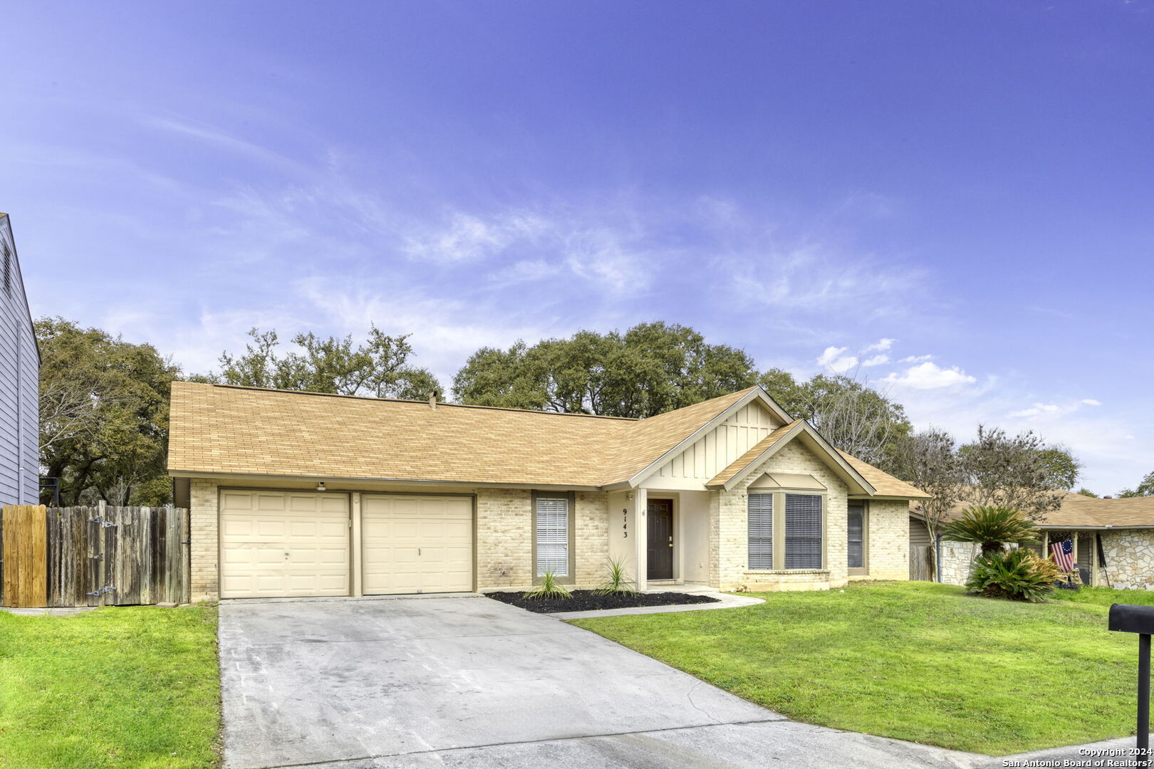 a front view of a house with a garden and yard