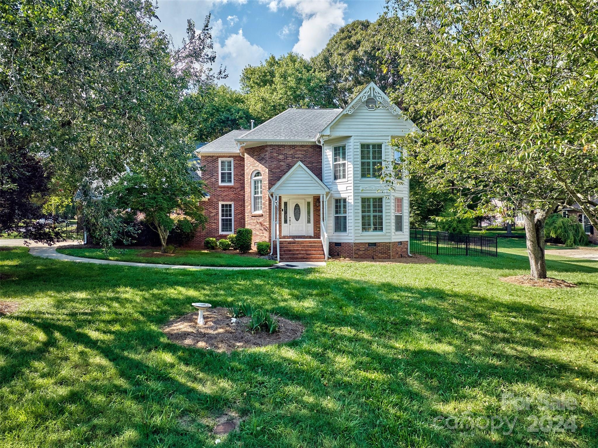 a front view of a house with a yard and trees