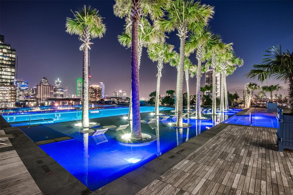 a view of swimming pool with red chairs and potted plants