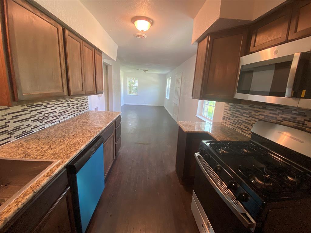 a view of an oven and wooden cabinets