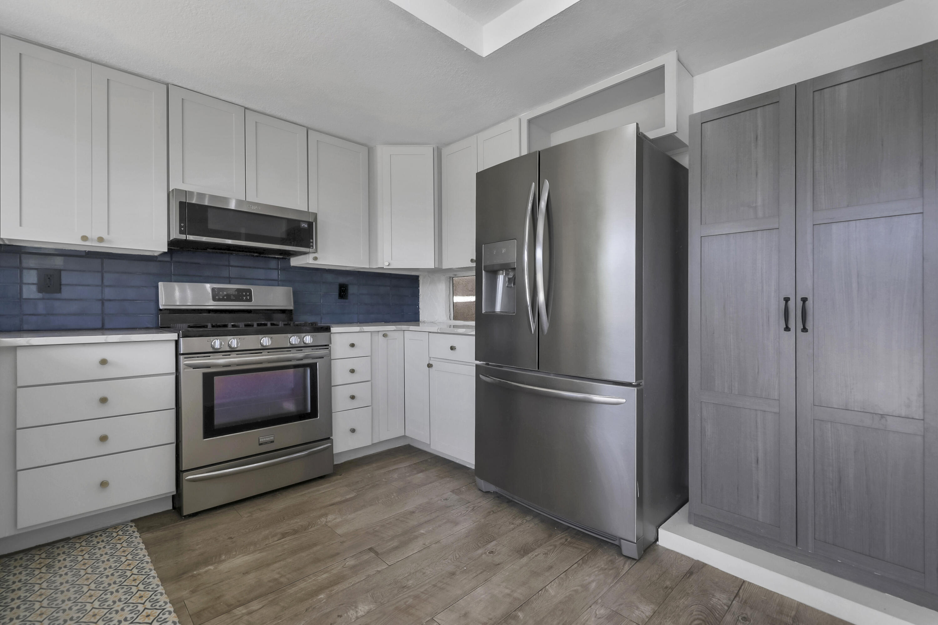 a kitchen with cabinets stainless steel appliances and a window