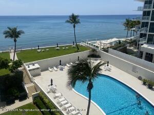 a view of a swimming pool with a yard and patio