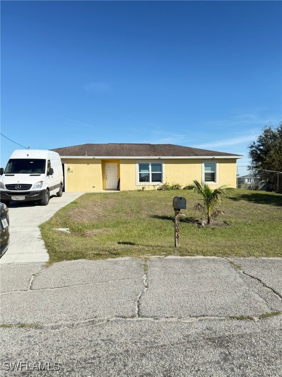 a view of backyard of house and car parked