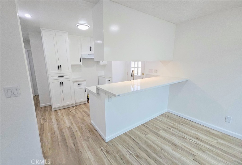 a kitchen with a sink window and cabinets