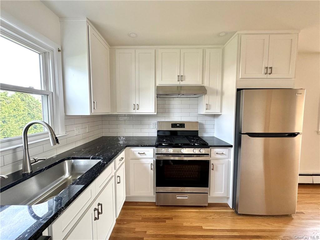 a kitchen with a stove a refrigerator and a sink