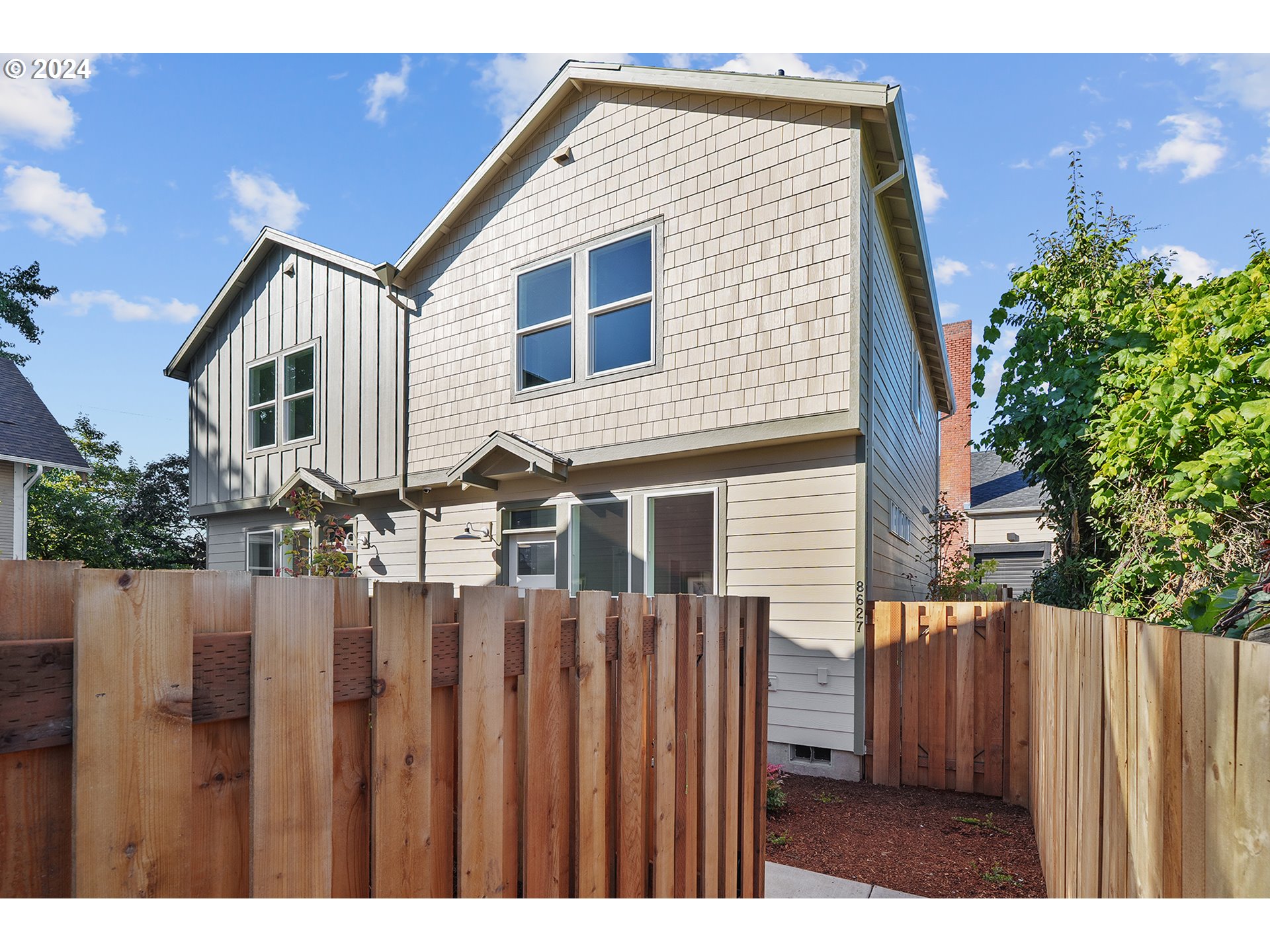 a view of a house with wooden fence