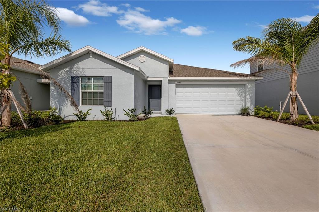 Ranch-style house with a garage and a front lawn