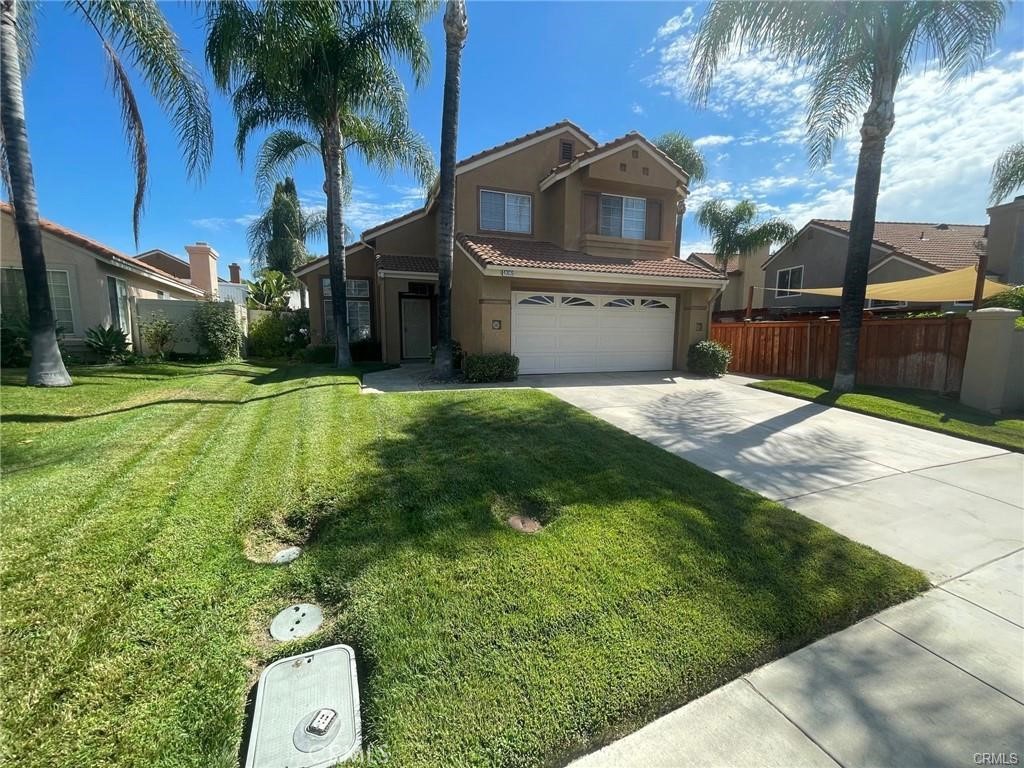 a view of a house with a yard and potted plants