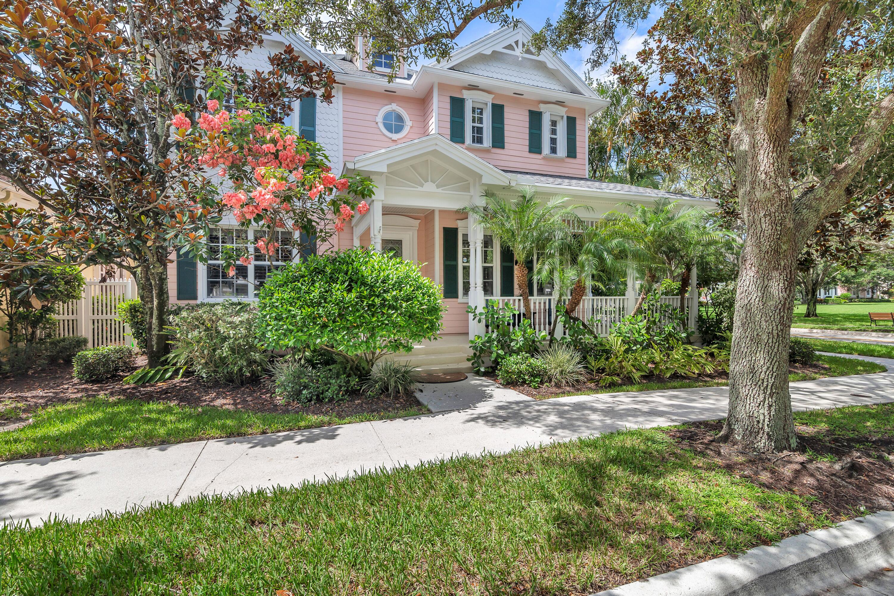 a front view of a house with a yard and potted plants