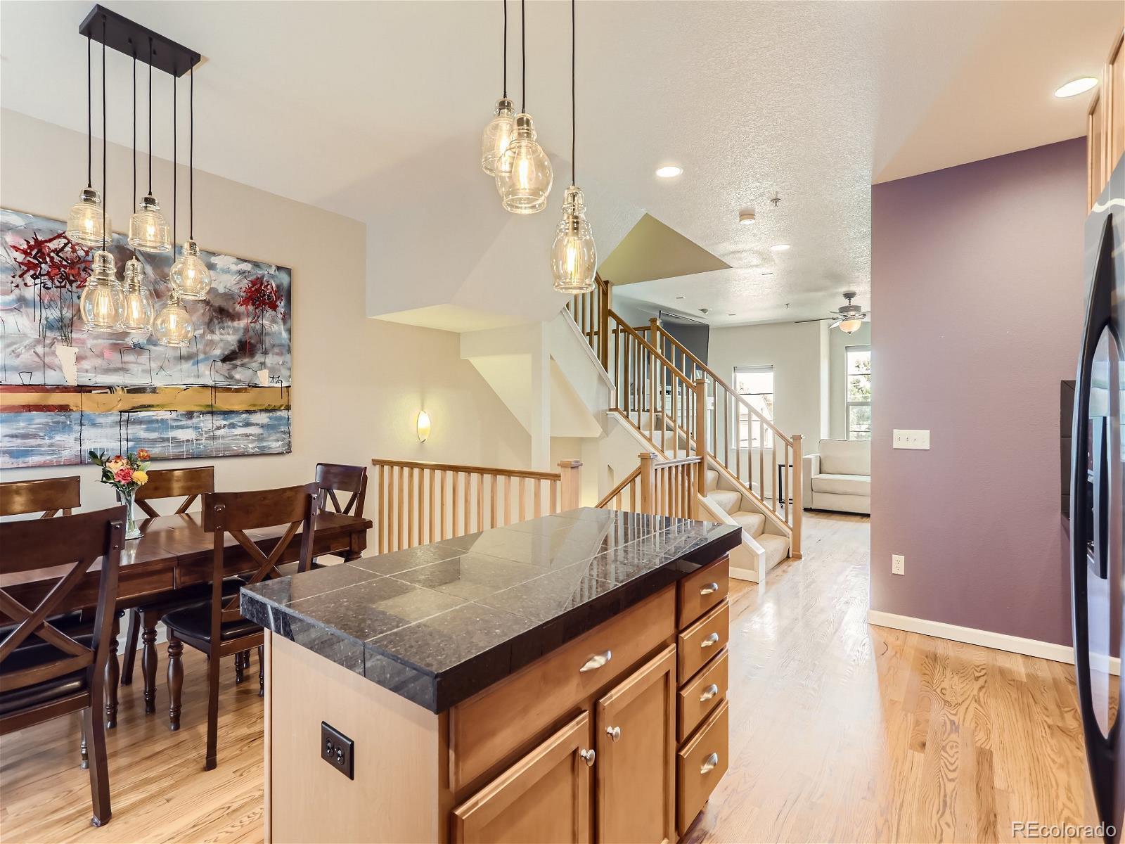 a kitchen with granite countertop a table chairs and a chandelier