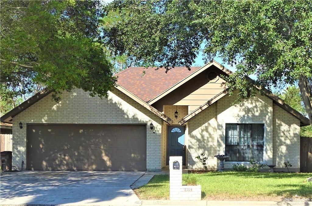 View of front of property with a garage and a front lawn