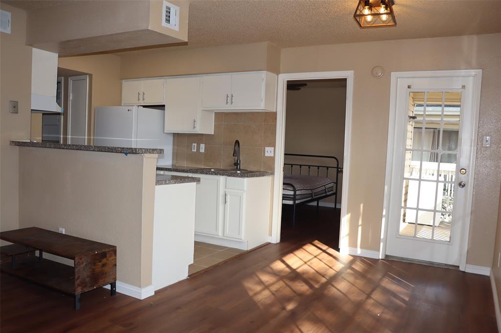 a kitchen with a refrigerator and a stove top oven