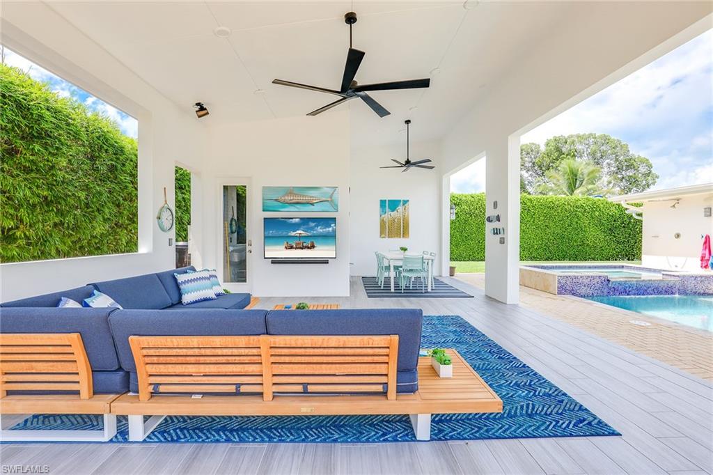 a living room with couch floor to ceiling window and a flat screen tv