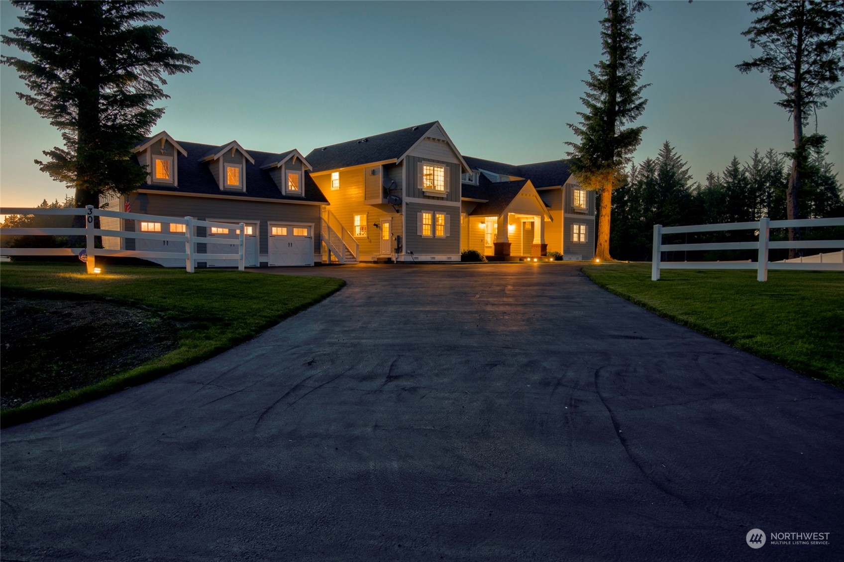 a view of a big house with wooden fence