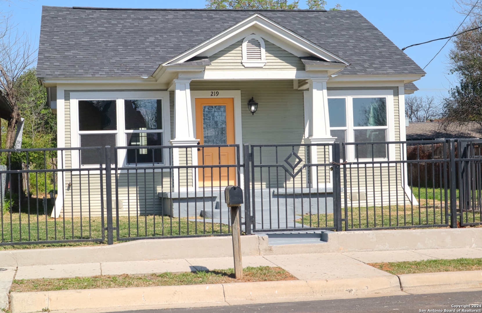 a view of a house with a wooden fence