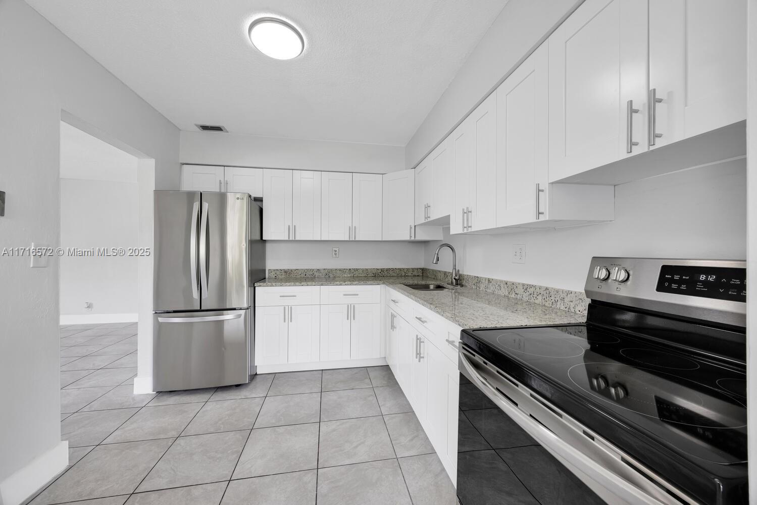 a kitchen with stainless steel appliances granite countertop a refrigerator sink and stove