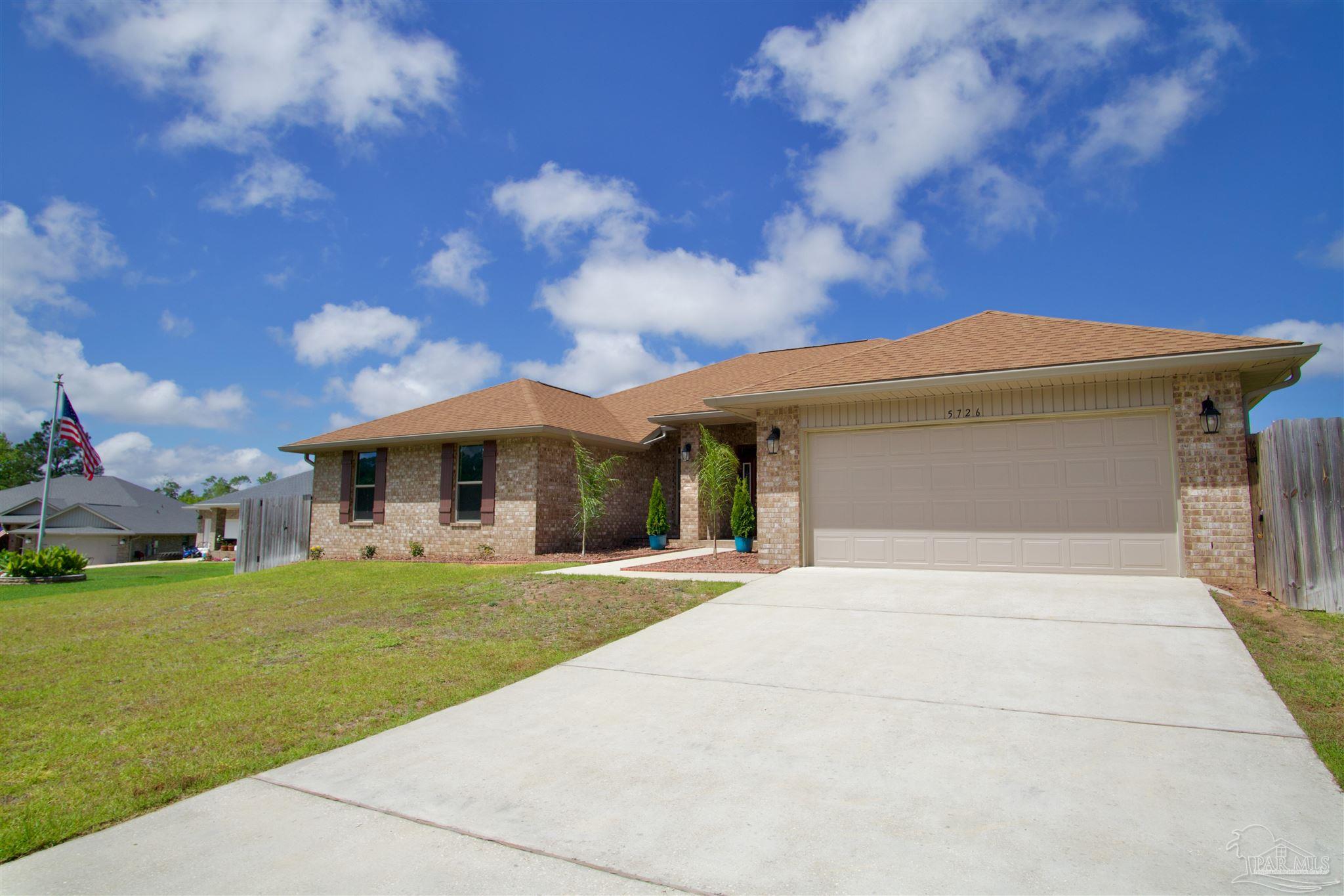 a front view of a house with a garden and yard