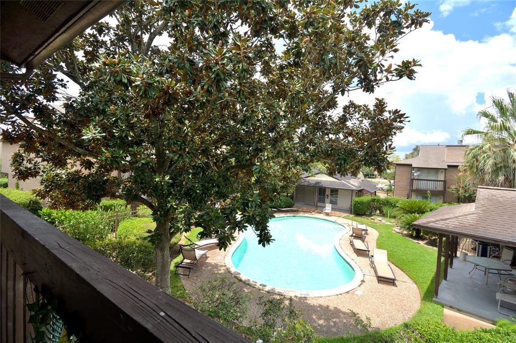 a view of a swimming pool with a patio and a yard