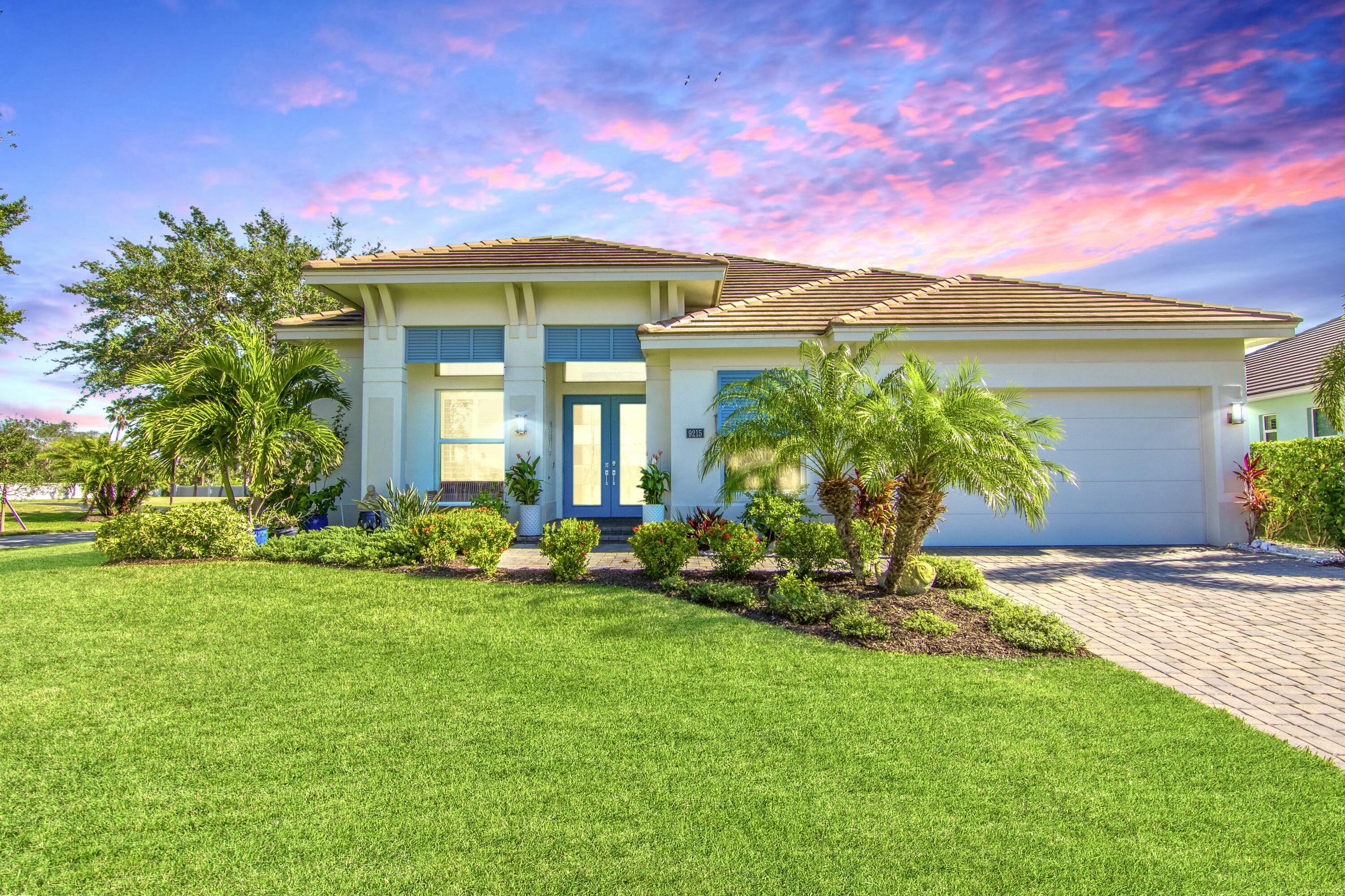 a front view of a house with a garden and plants