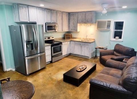 a kitchen with stainless steel appliances granite countertop a refrigerator a stove and a sink