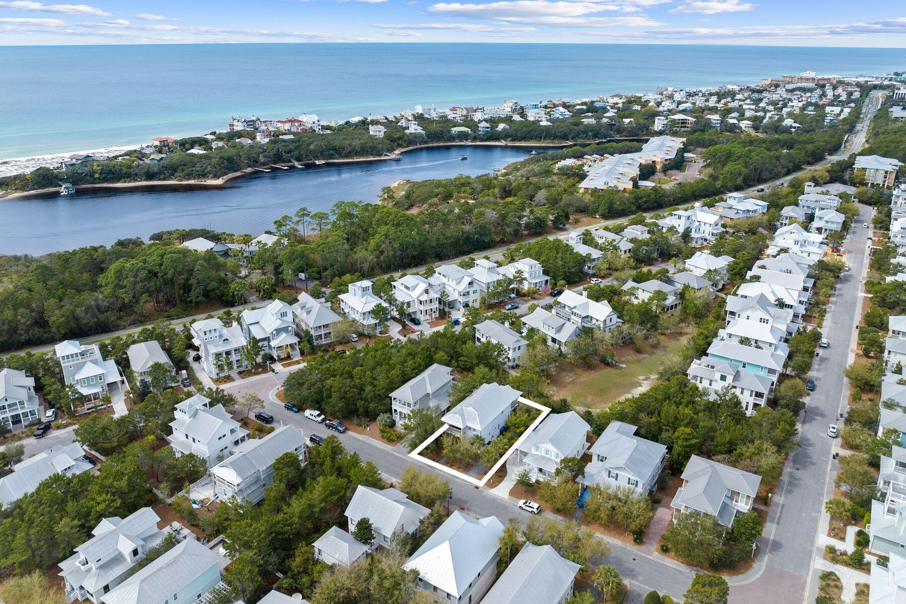 an aerial view of ocean and residential houses with outdoor space