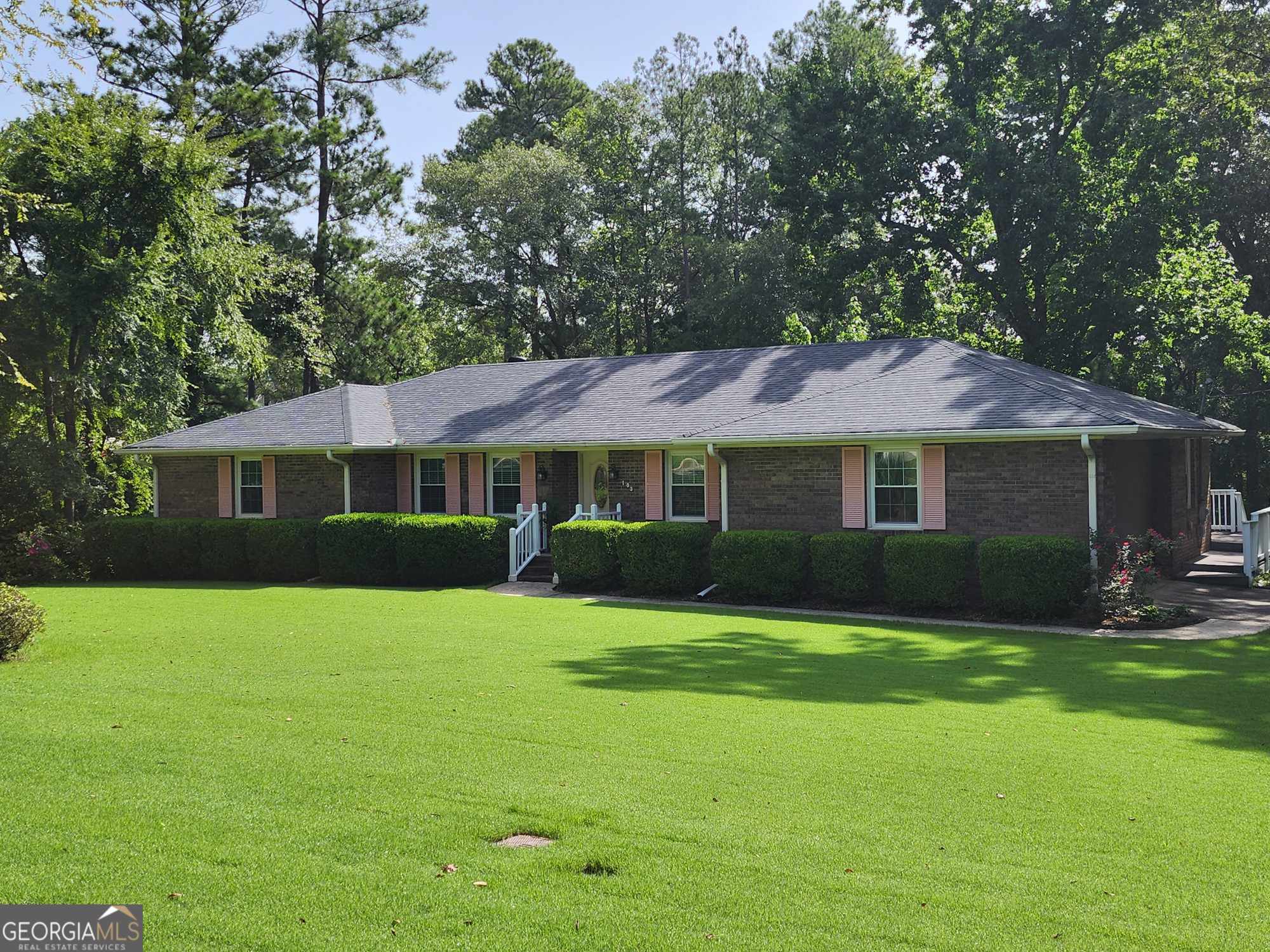 a front view of a house with a yard and trees