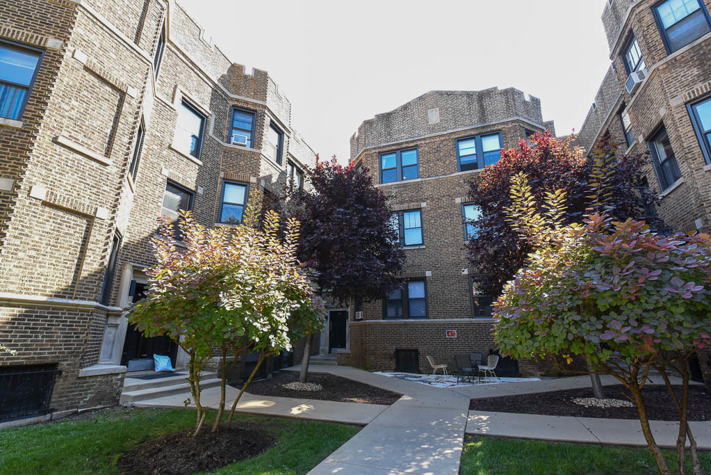 a front view of a multi story building with yard