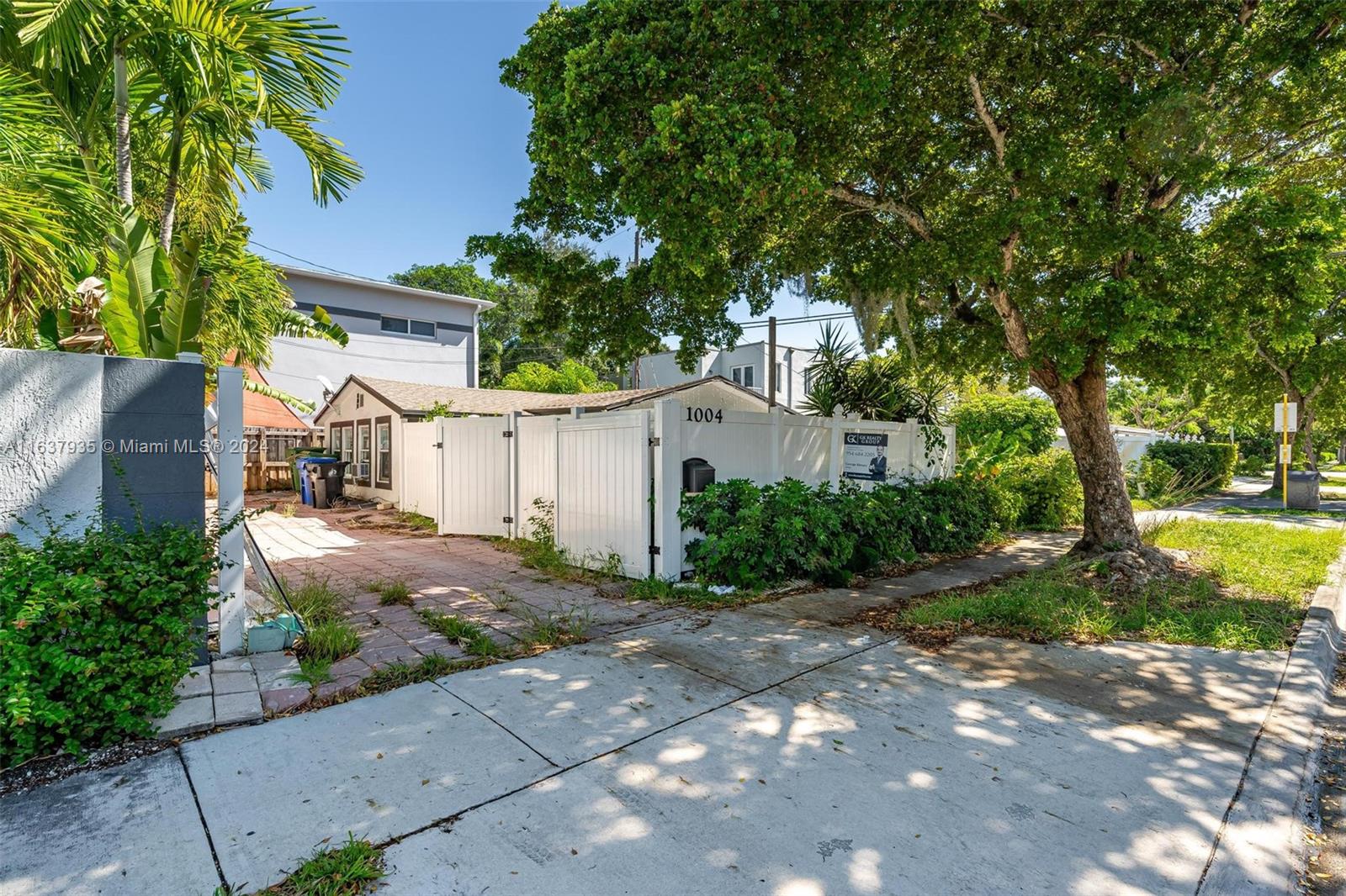 a front view of a house with a yard and a tree