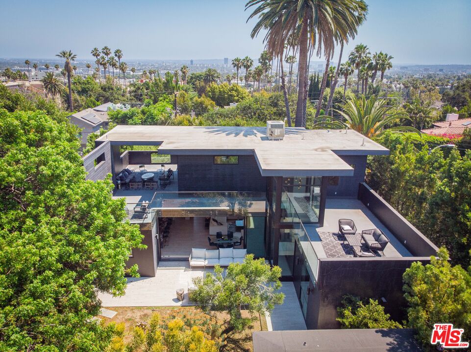 an aerial view of a house with swimming pool garden and patio