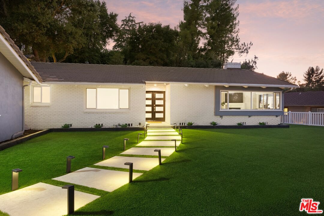 a front view of a house with a garden and yard