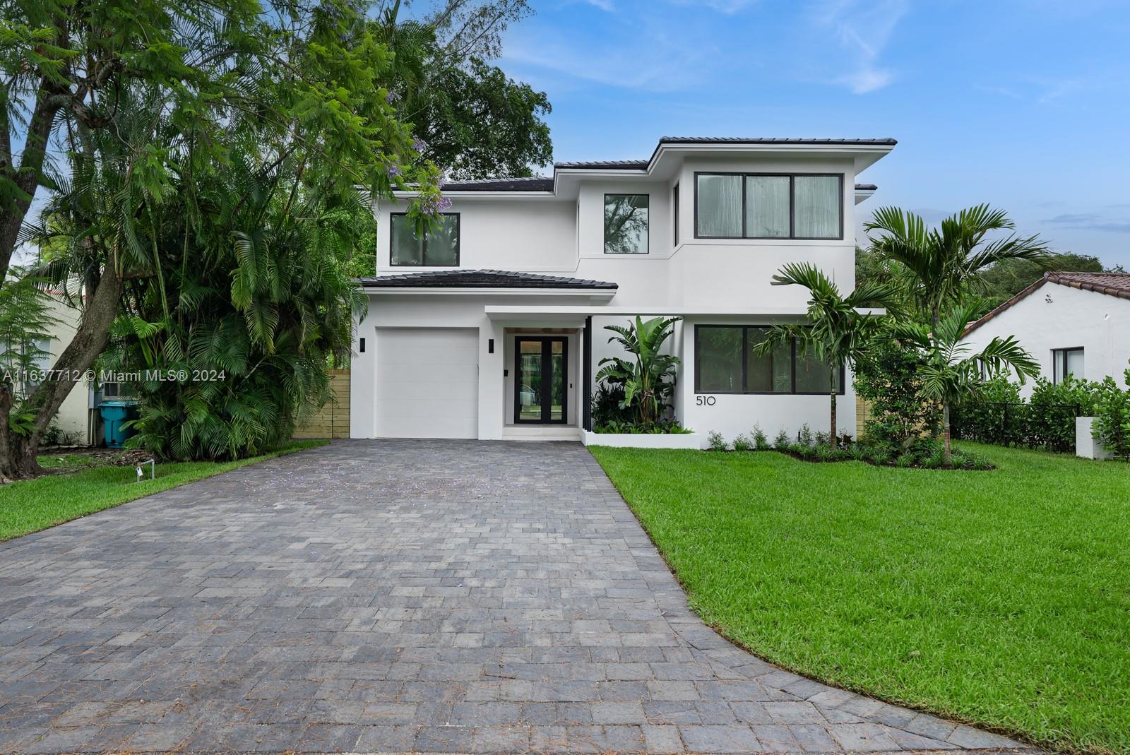 a front view of a house with a yard and trees