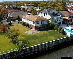 a view of a house with wooden deck and a yard