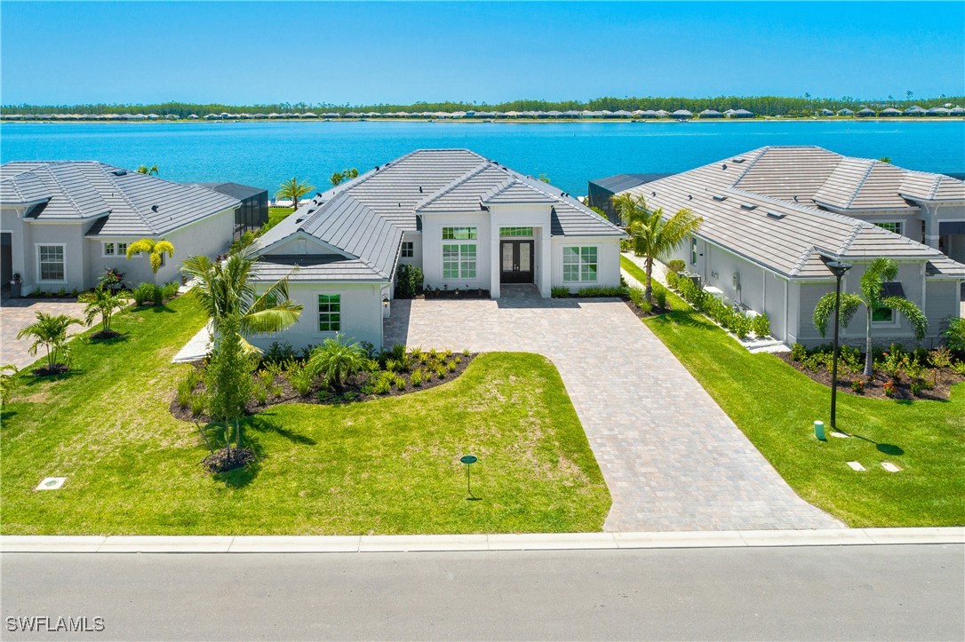 an aerial view of a house with outdoor space lake view and mountain view in back