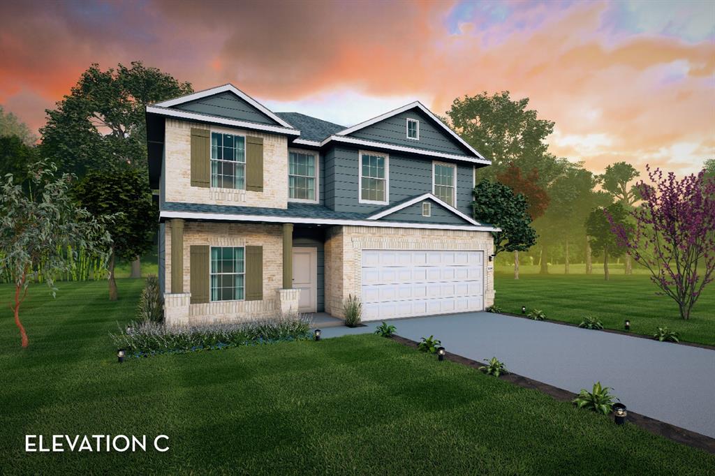 a front view of a house with a garden and yard