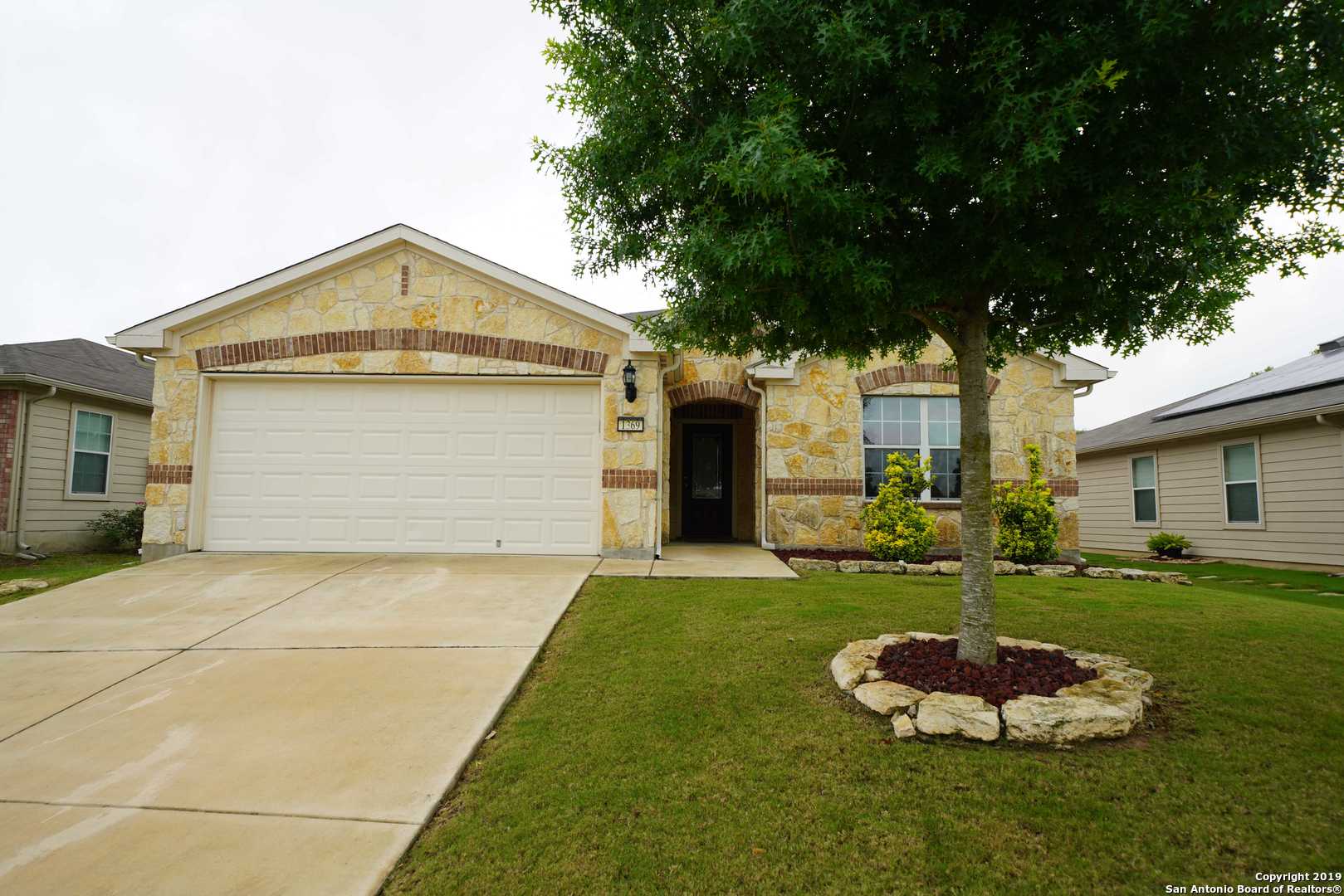 a front view of a house with a garden and yard