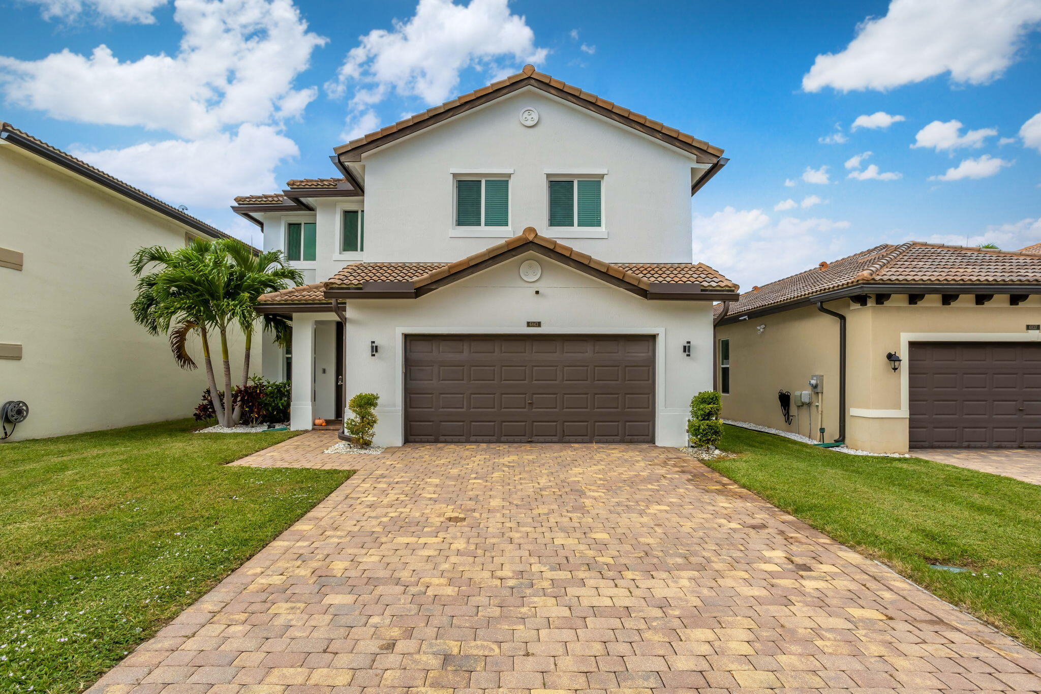 a front view of a house with a yard and garage