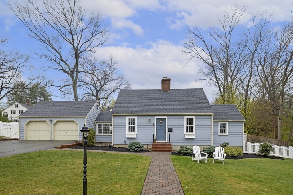 a front view of a house with a yard and trees